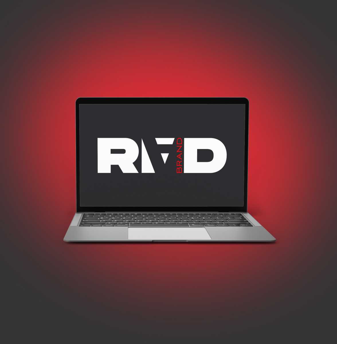 Пример веб-разработки: ноутбук с логотипом RAD на экране на красном фоне