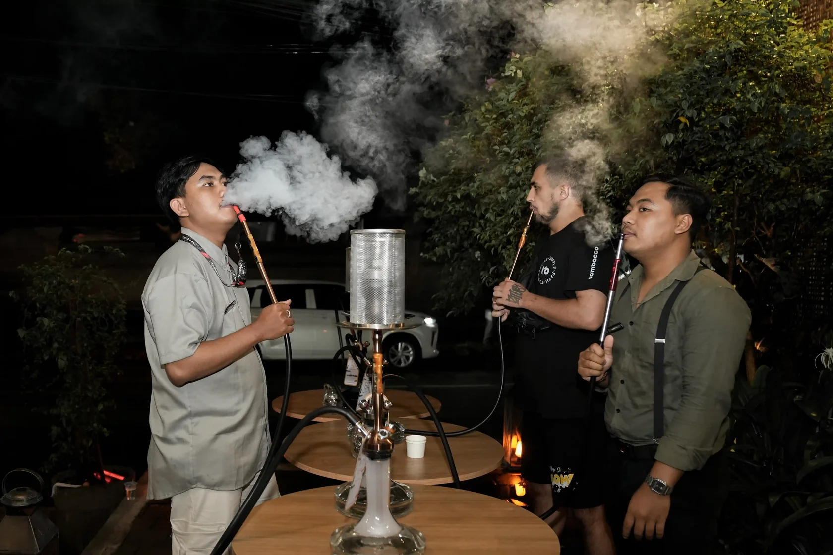 A group of friends enjoying a relaxing evening outdoors, showcasing proper etiquette during a premium shisha delivery in Bali experience.