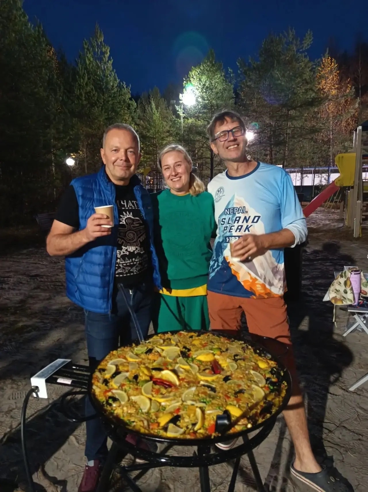 Паэлья с морепродуктами готовится на огне в большой сковороде
