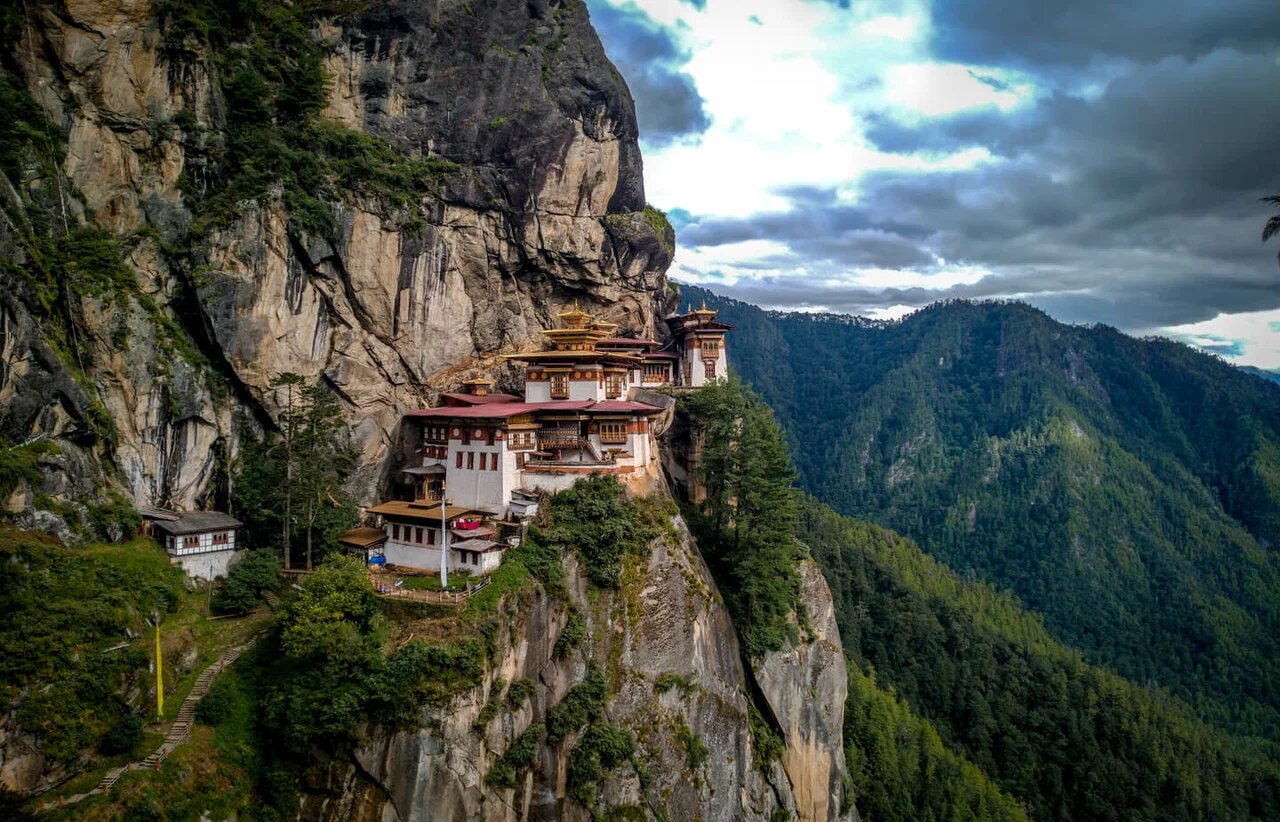 Бутан индия. Монастырь в бутане. Монастырь в бутане в горах и скалах. Гнездо тигрицы в бутане фото. Монастырь на склоне.