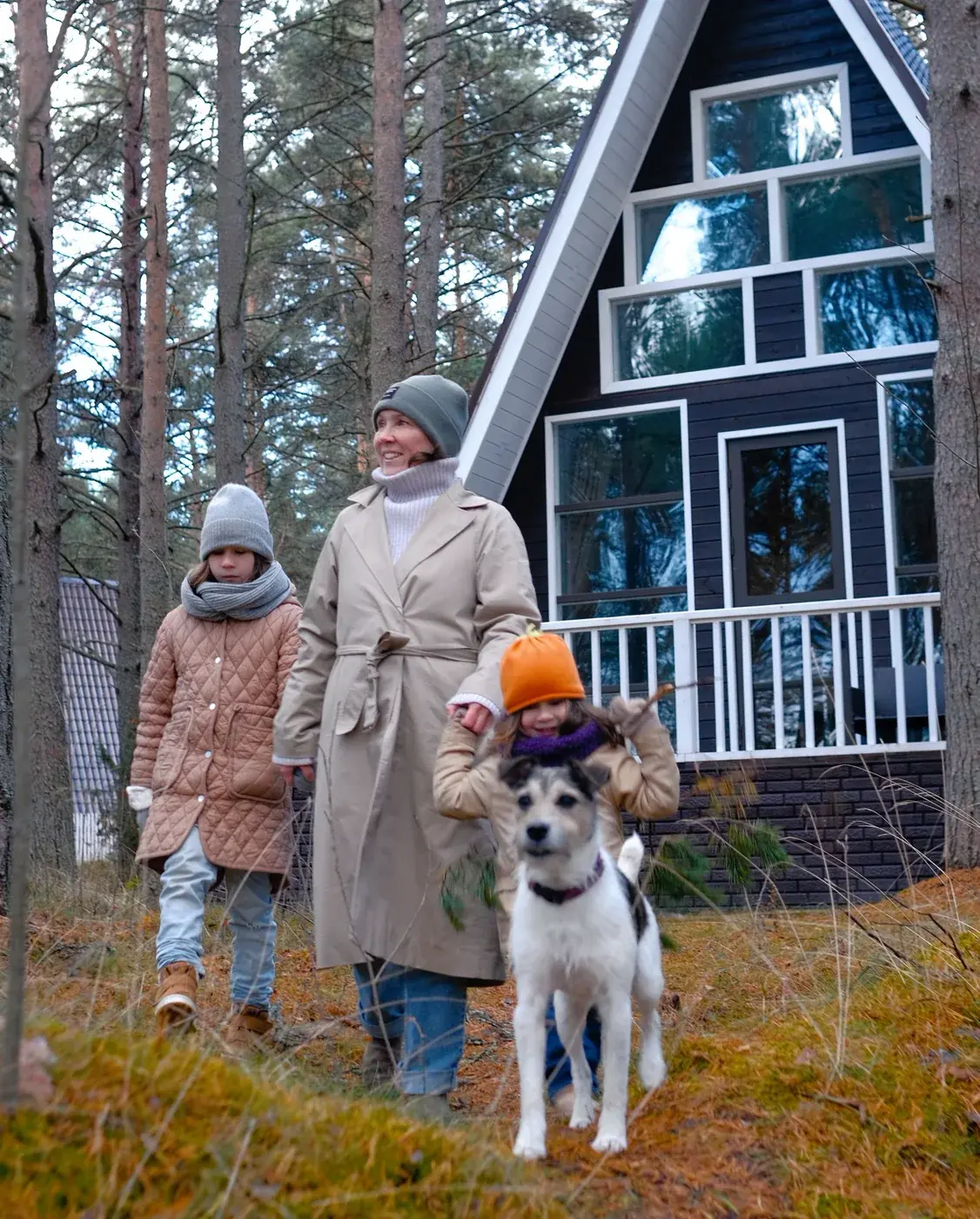 Семья с собакой гуляет у A-Frame осенью