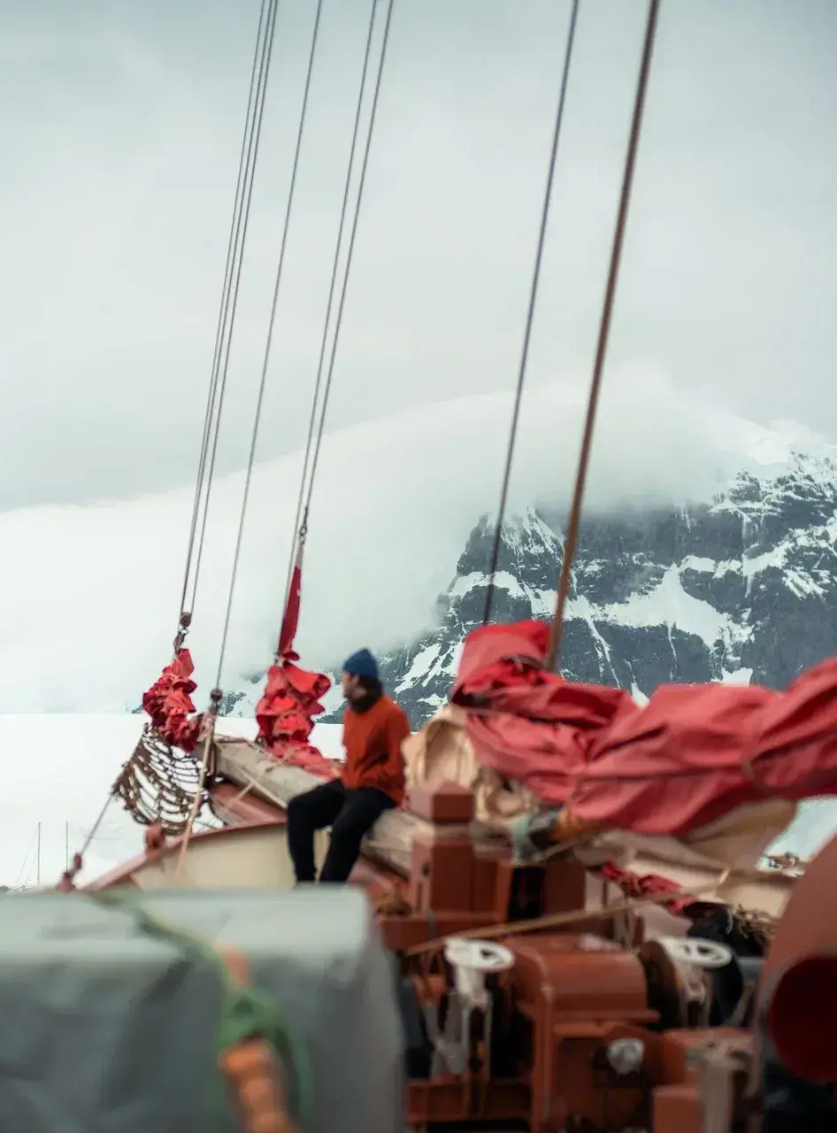 Expedition sailing schooner anchored in Antarctica surrounded by glaciers and snowy peaks