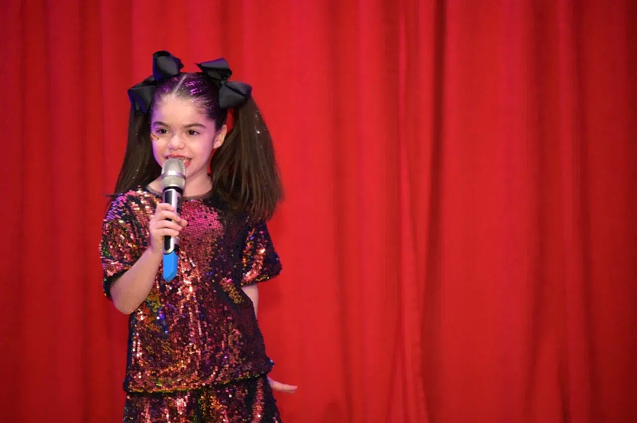 Девочка выступает на концерте и поет в микрофон