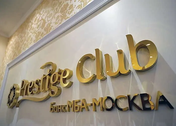 Латунная вывеска prestige club с дополнительной строкой на интерьерной стене
