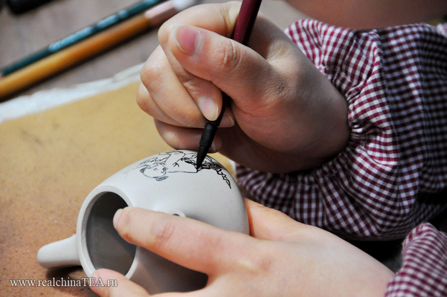 Все, абсолютно все в исинских чайниках делается вручную. Даже рисунок. Мастер сначала наносит изображение специальным карандашом. Затем оно покрывается термостойким прозрачным лаком и чайник отправляется в печь.