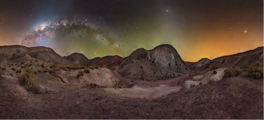 A landscape of a desert with hills and a starry sky

Description automatically generated