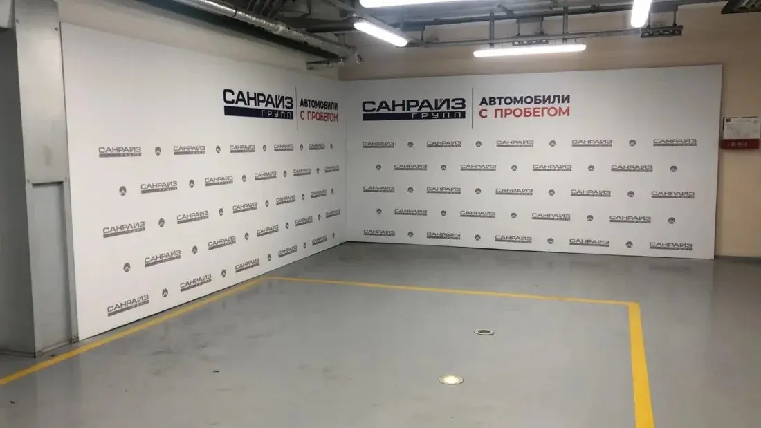 Угловой пресс-волл из двух белых баннерных стен с логотипами