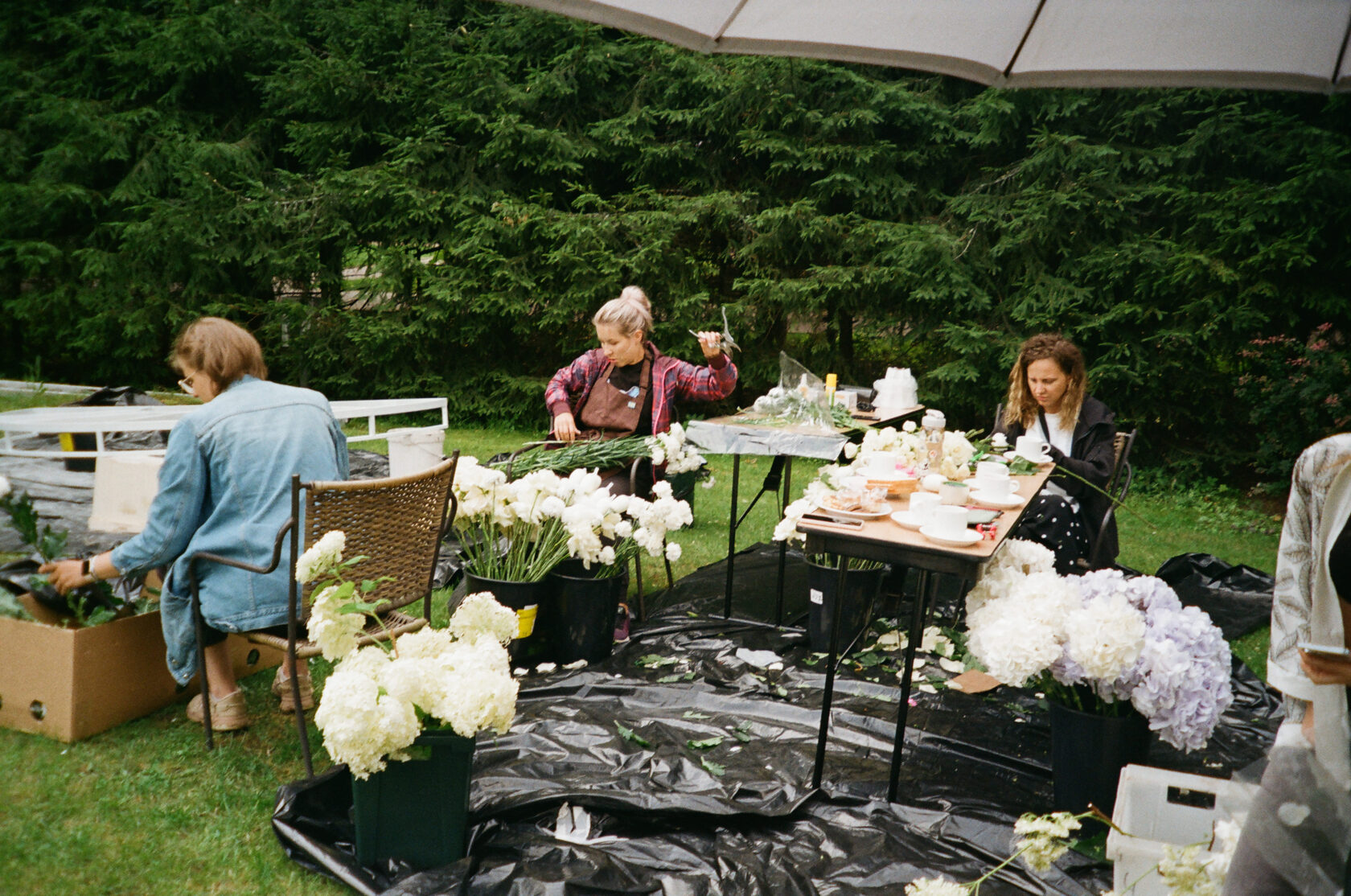 флористы собирают цветочные композиции для выездной церемонии и банкета