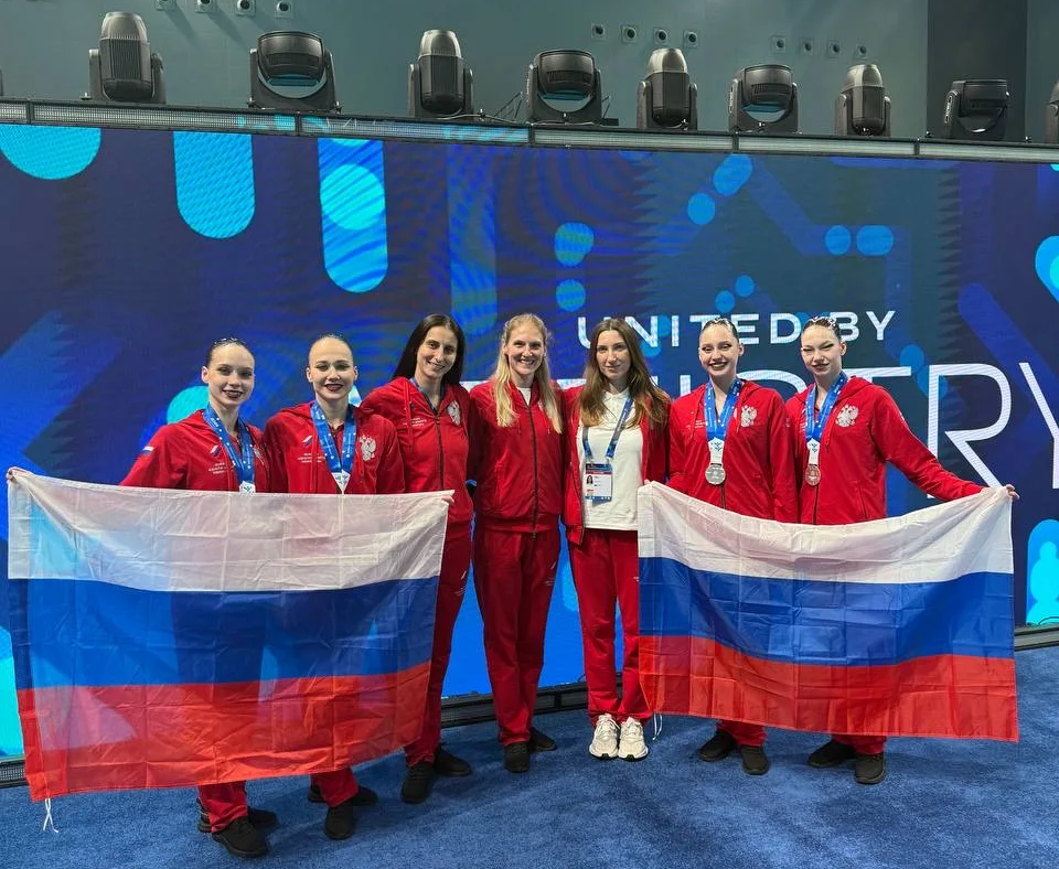 Российский дуэт Кира Черезова и Валентина Герасимова на церемонии награждения Кубка мира по синхронному плаванию в Сиане с флагом РФ.