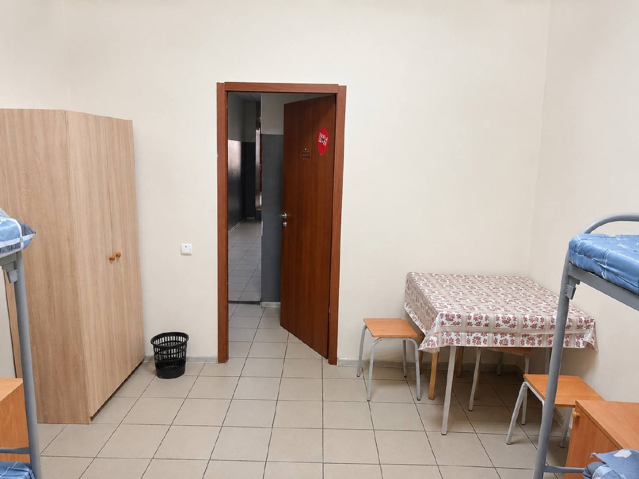Шкаф, стол и вход в комнату — четырёхместный номер в хостеле в Люберцах