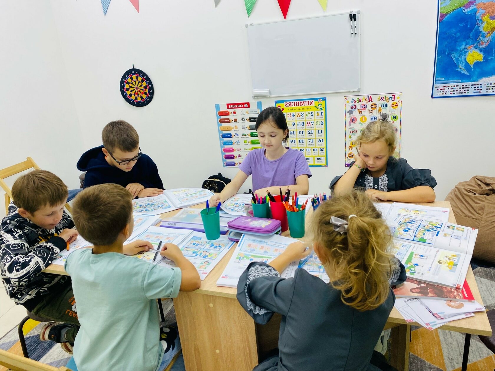 Занятие в детском центре по английскому языку группой детей 