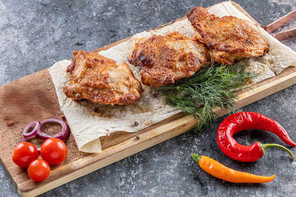 Куриные бедра на доске с укропом и специями