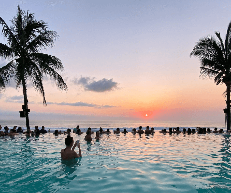 Groups of people enjoy sunset in seminyak beach