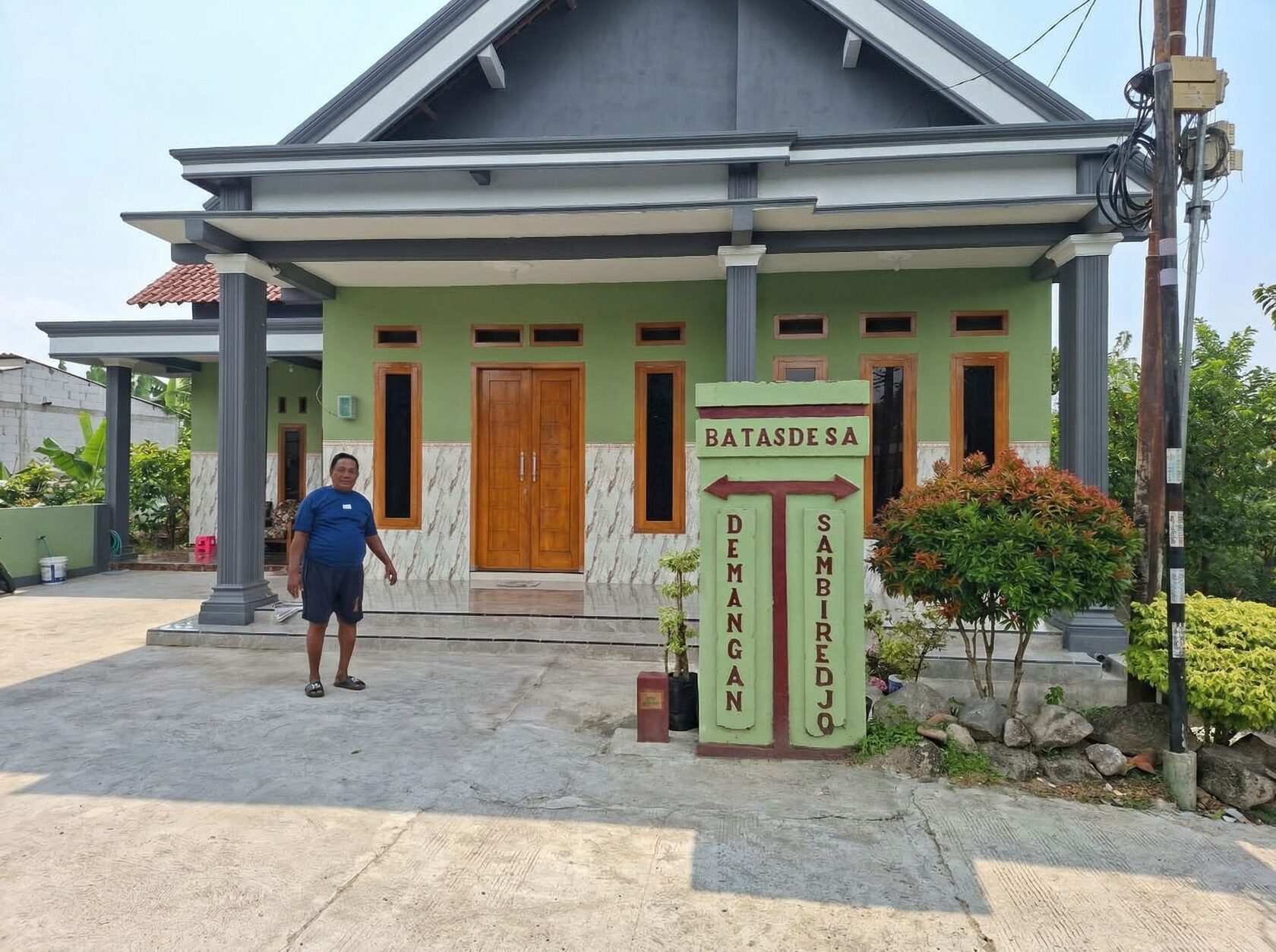 Rumah terbelah di Nganjuk dengan tugu batas Desa Demangan dan Sambirejo
