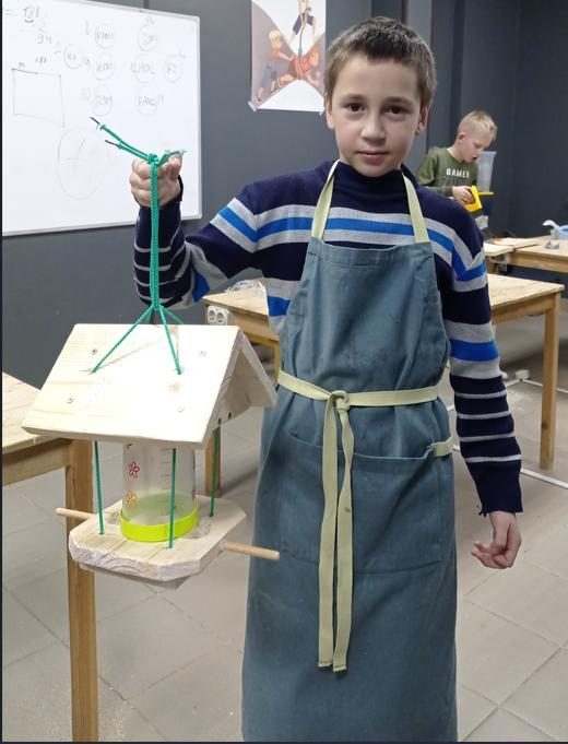 Ученик с собранной кормушкой для птиц