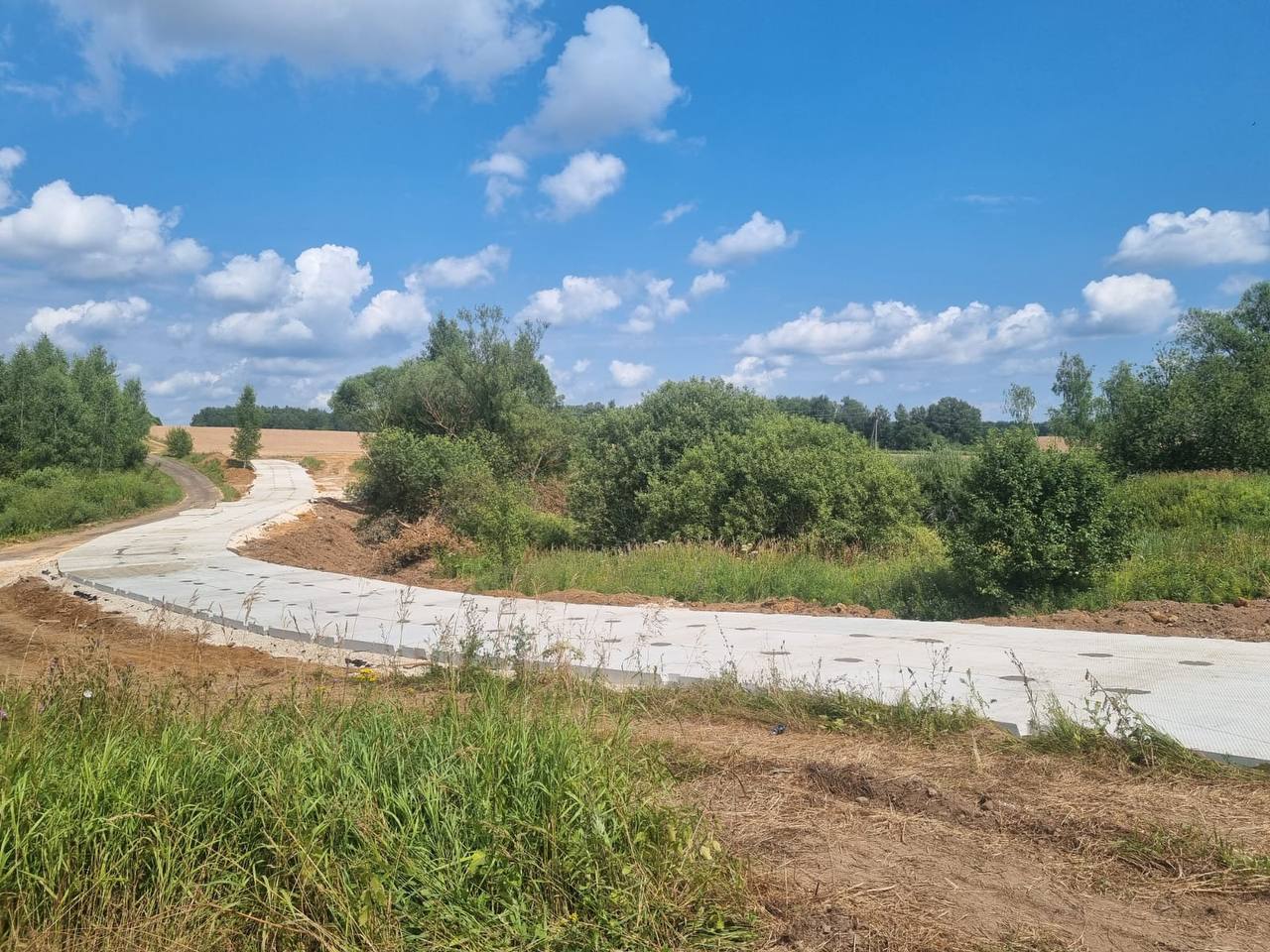 Готовая дорога из дорожных плит, уходящая вдаль в Ступино, Тульская область, после завершения укладки СигмаК.