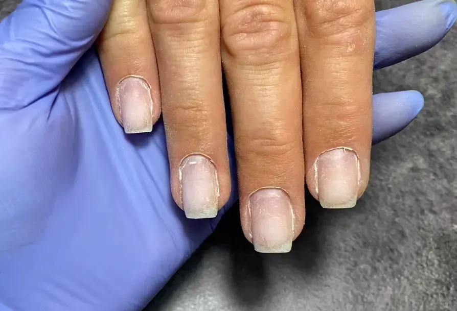 Чистая ногтевая пластина после безопасной обработки фрезой, кутикула без повреждений.