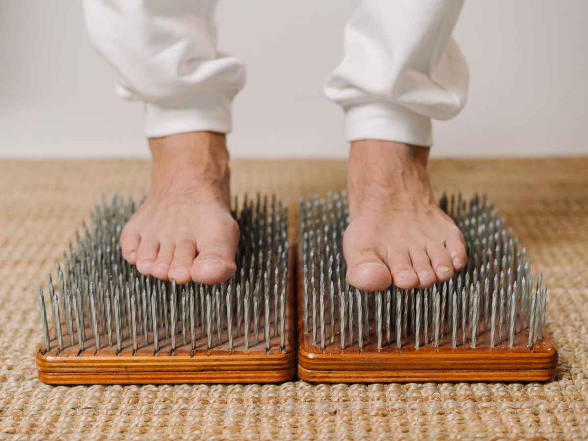 Ноги на доске с гвоздями