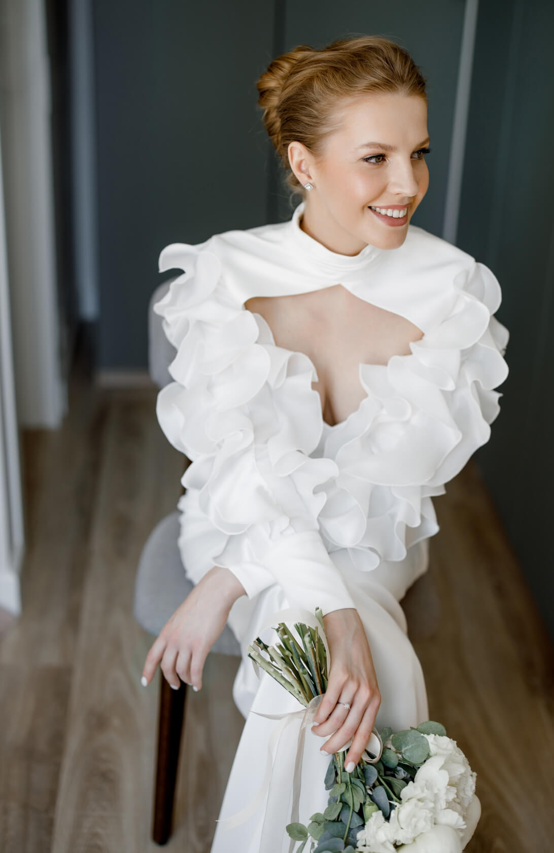 Невеста с пучком сидит и держит букет