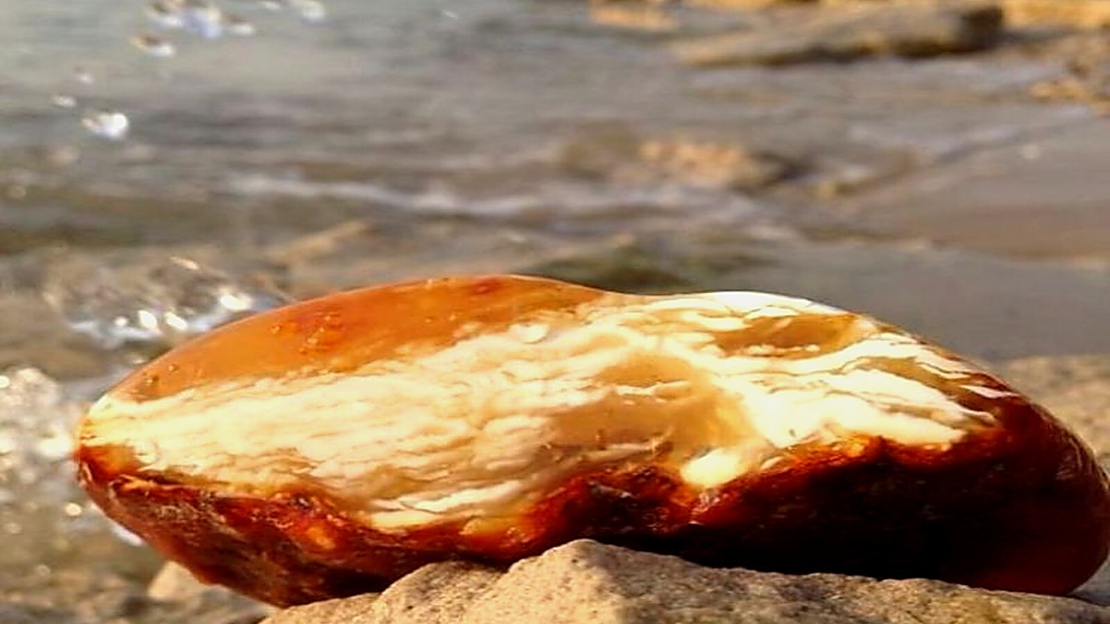 natural amber stone in water close up warm light