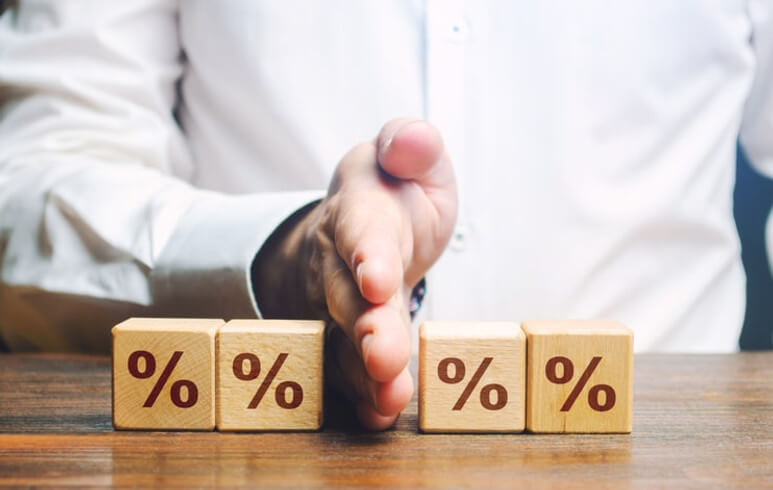 рука мужчины делит деревянные кубики 2 по левую сторону и 2 по правую на которых вырезаны проценты