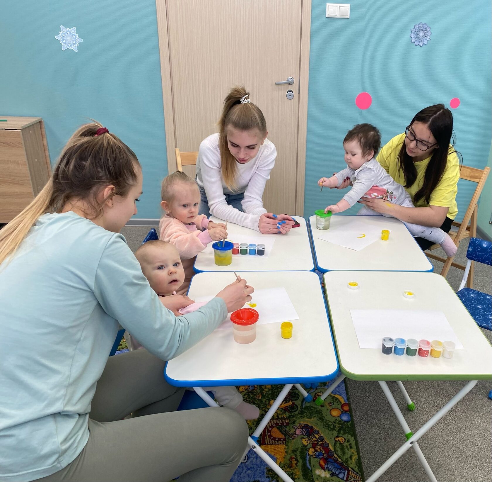 мамы с малышами рисуют на занятии в детском центре
