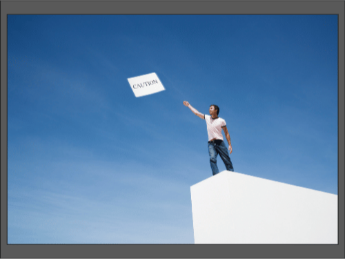 Мужчина стоит на крыше и бросает в небо табличку с надписью «Caution».