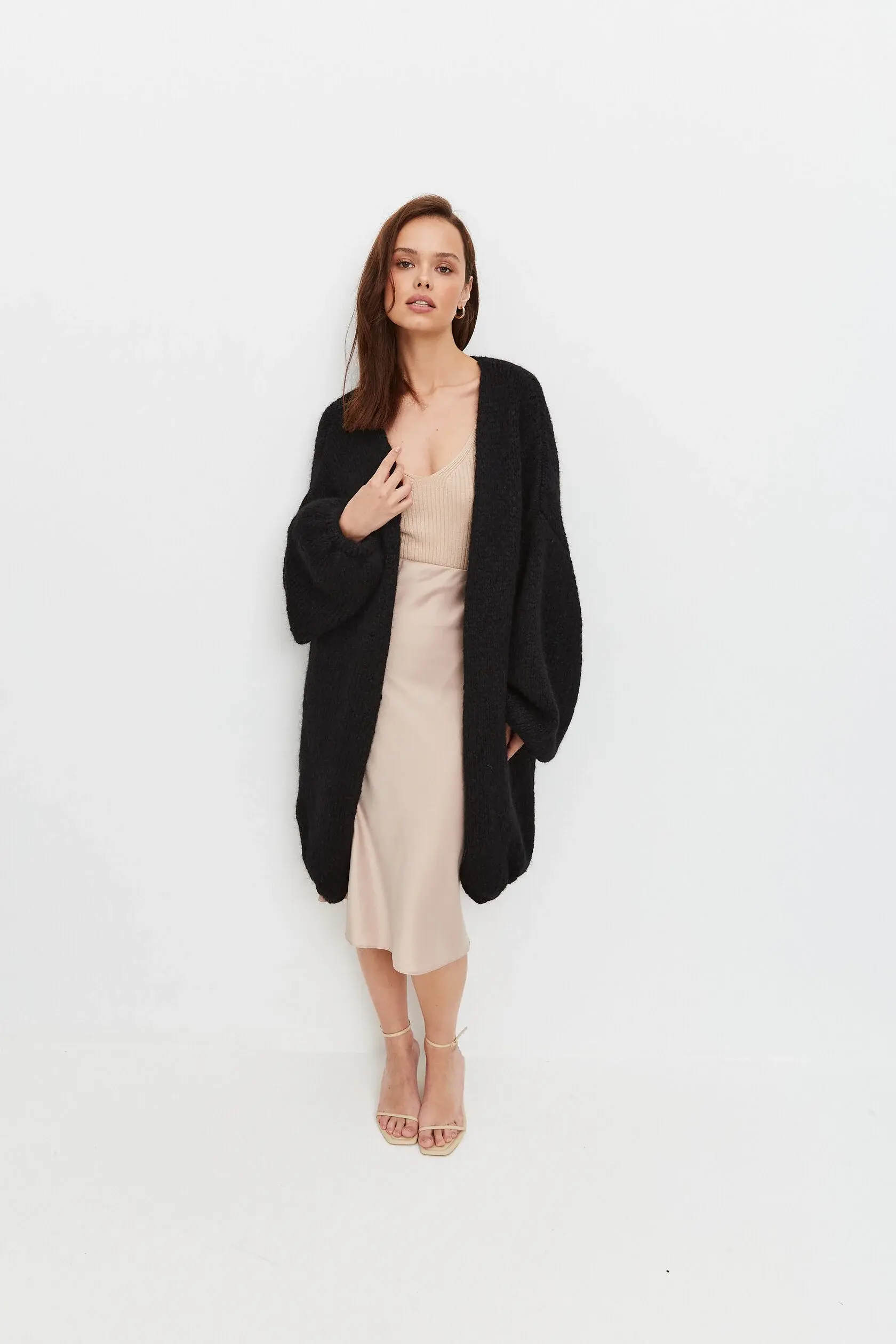 Женственный образ: вязаный кардиган оверсайз поверх платья миди из шелковистой ткани.