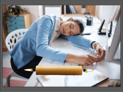 Уставшая женщина заснула за рабочим столом, добавлена свеча, горящая с двух концов.