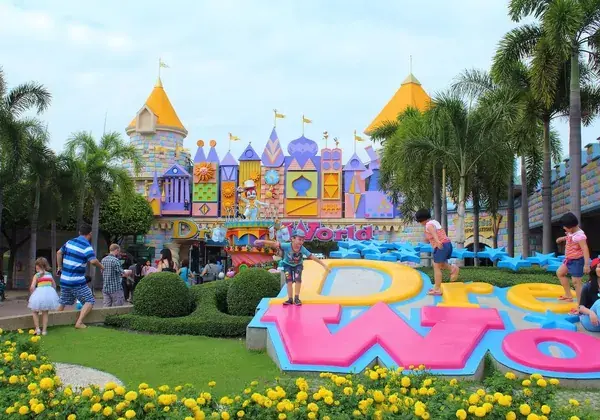 Дети у объёмных букв Dream World на фоне яркого замка, тайский Диснейленд