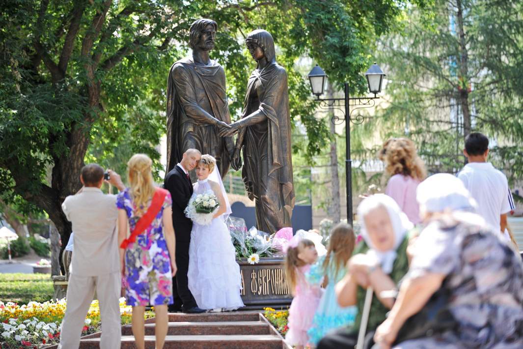 Молодожёны фотографируются у памятника Петру и Февронии в Муроме