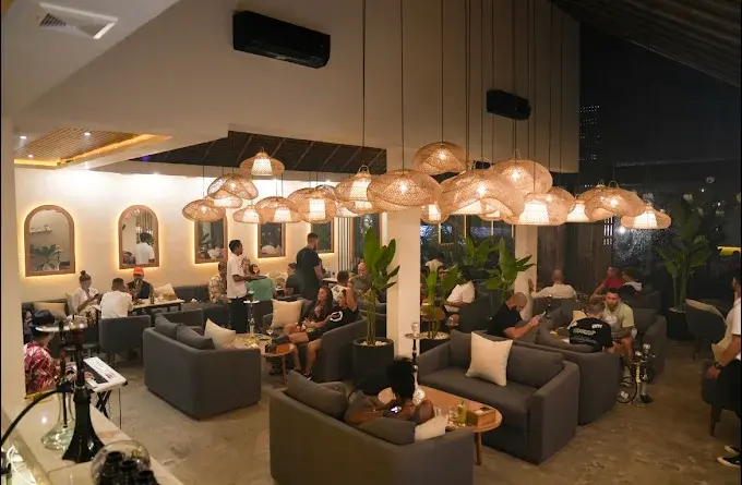 A relaxed workspace setting with laptops, a fresh shisha pipe, and great Russian food in Bali at Eden Hookah Club Canggu, perfect for daytime productivity.